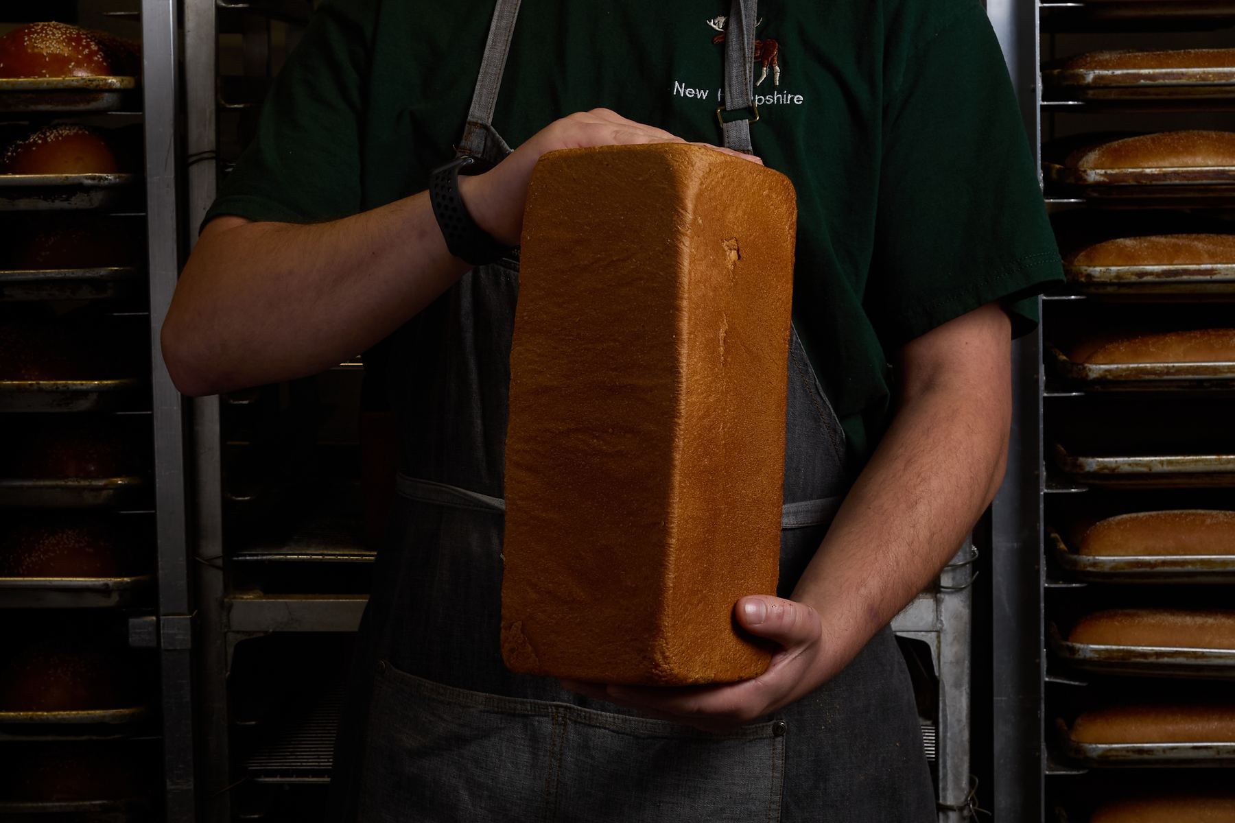 Baker holding a milk bread loaf